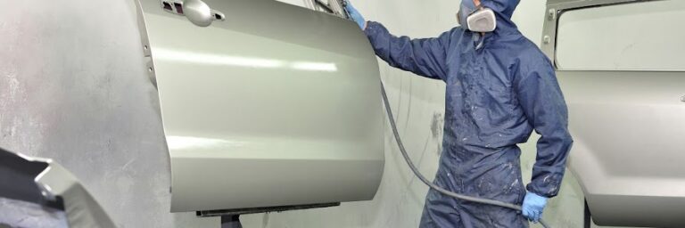 Worker painting car door.